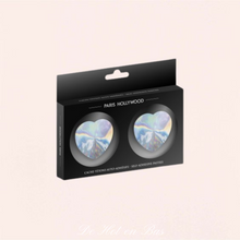 Charger l'image dans la galerie, La paire de cache seins hologramme de couleur argenté en forme de coeur est livré dans une petite boite noire de la marque Paris Hollywood.