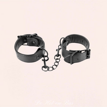 Charger l'image dans la galerie, Une paire de menottes jolie mais aussi torride en simili cuir noir ajustables pour vos moments fétichistes avec votre partenaire.