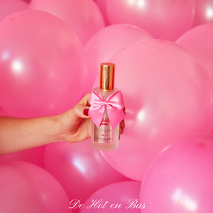 Le gel de massage, lubrifiant est présenté dans une bouteille en verre chic avec un nœud sexy rose satin.